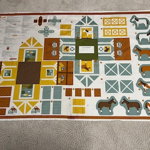 May include: A fabric panel featuring a barnyard scene with a variety of buildings, horses, and instructions. The design includes yellow, brown, and blue elements, with a white background and a brown border. The panel is designed for crafting.