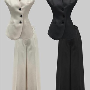 May include: Two matching business suits. One suit is off-white, featuring a vest with three black buttons and wide-leg pants. The other suit is black, with a similar vest and wide-leg pants. Both suits are displayed against a neutral background.