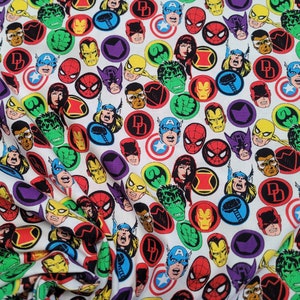 May include: White fabric with a repeating pattern of colorful superhero icons. The icons include Spider-Man, Captain America, Hulk, Iron Man, Thor, and Daredevil.
