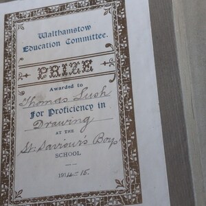 May include: A vintage certificate from the Walthamstow Education Committee, awarded to Thomas Lush for proficiency in drawing. The certificate features ornate brown borders and text, with the date 1914-15 at the bottom.