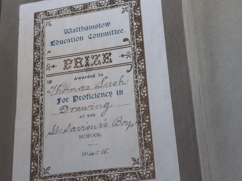 May include: A vintage certificate from the Walthamstow Education Committee, awarded to Thomas Lush for proficiency in drawing. The certificate features ornate brown borders and text, with the date 1914-15 at the bottom.
