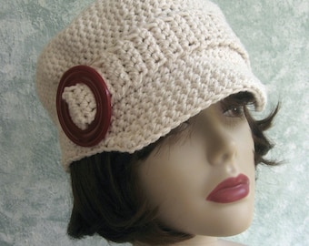 May include: A crocheted hat with a wide brim and a red button. The hat is off-white and has a simple stitch pattern.