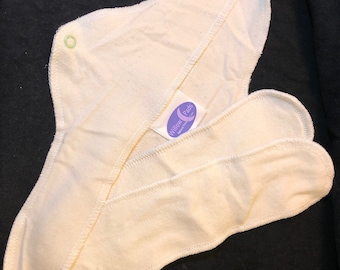 May include: A white reusable cloth menstrual pad with a purple and white label that says "Willow Pads".