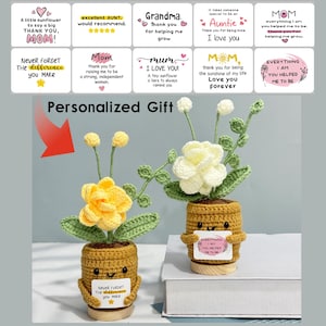 May include: Two handmade crochet flower arrangements in small pots. One pot has a yellow flower, the other has a white flower. Each pot has a small sign with text. The image also includes text that says "Personalized Gift".