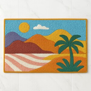 Op de afbeelding: Een rechthoekige, kleurrijke deurmat met een landschapsscène. Het ontwerp omvat een blauwe lucht met een gele zon en een witte wolk, bergen in oranje, rood en paars, een palmboom en een gestreepte strand. De rand is geel.