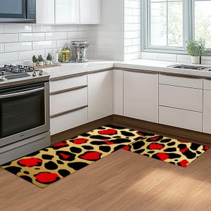May include: Two kitchen rugs with a leopard print pattern in shades of black, red, and gold. The rugs are placed in a corner of a kitchen with white cabinets.