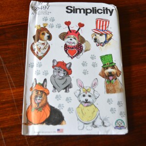 Könnte beinhalten: Simplicity-Schnittmuster mit Illustrationen von Hunden in Kostümen, darunter ein patriotischer Hut, Hasenohren und ein Kürbiskostüm. Das Muster ist für Hundebekleidung und -zubehör.