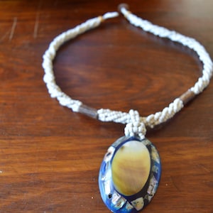 Collana vintage - Ciondolo ovale artigianale con intarsi in abalone e madreperla, cordino intrecciato di perline e chiusura a bottone in conchiglia.