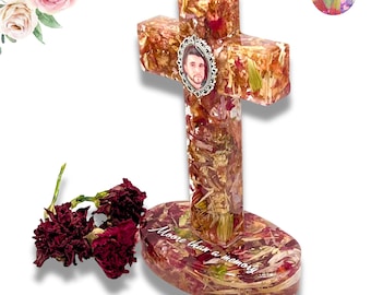 May include: A resin cross and oval base filled with dried flower petals in shades of red, pink, and green. The cross features a small oval portrait of a person in a silver frame at the center. The base has the white text Moore than a memory.