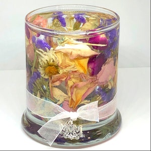 May include: A clear glass jar filled with dried flowers and a white ribbon with a silver charm that says "MOM".