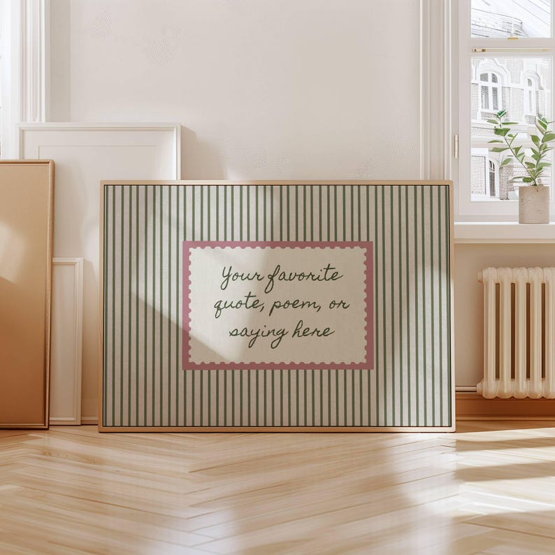 May include: A rectangular framed print featuring a light green and white vertical striped background. In the center, a cream-colored rectangular label with a scalloped pink border displays the black cursive text: Your favorite quote, poem, or saying here.