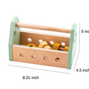 May include: A wooden toy toolbox with light green side panels and a natural wood handle. The box features circular holes and contains yellow wooden nuts and bolts. Dimensions are 8.25 inches in length, 4.5 inches in width, and 5 inches in height.