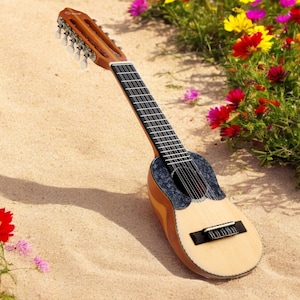 Könnte beinhalten: Eine braune Holzsitar mit einem schwarz-weißen Muster auf dem Korpus, die auf einem Sandstrand mit rosa und gelben Blumen im Hintergrund liegt.