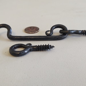 May include: Black metal hook and eye latch with a screw for attaching to a door or gate.