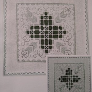 May include: A black and white embroidery pattern with a cross-shaped design. The pattern is surrounded by a border of small squares. The pattern is on a white background.