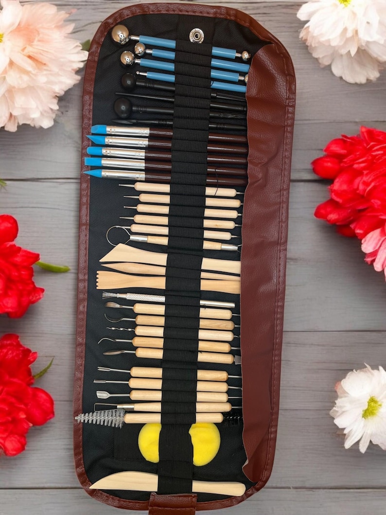 K&ouml;nnte beinhalten: Eine braune Ledertasche mit Rei&szlig;verschluss enth&auml;lt ein Set mit 30 Werkzeugen zum Modellieren von Polymer Clay. Die Werkzeuge sind in Reihen angeordnet und umfassen verschiedene Formen, Gr&ouml;&szlig;en und Materialien wie Metall, Holz und Kunststoff.