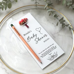 The seeded pencil is on a personalized card. There are also colorful flowers on the card.