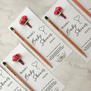 The seeded pencil is on a personalized card. There are also colorful flowers on the card.