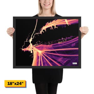 May include: A framed art print with a black frame. The artwork features a vibrant abstract design in shades of purple, orange, and yellow against a black background. The print measures 18" x 24".