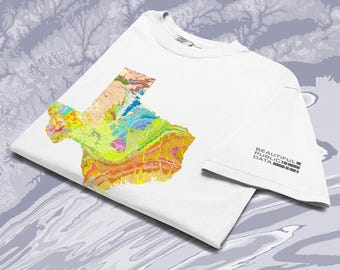 May include: A white short-sleeved t-shirt featuring a colorful geological map of Texas on the front. The sleeve displays the text "BEAUTIFUL PUBLIC DATA" in a black sans-serif font. The shirt is made of cotton and has a crew neckline.