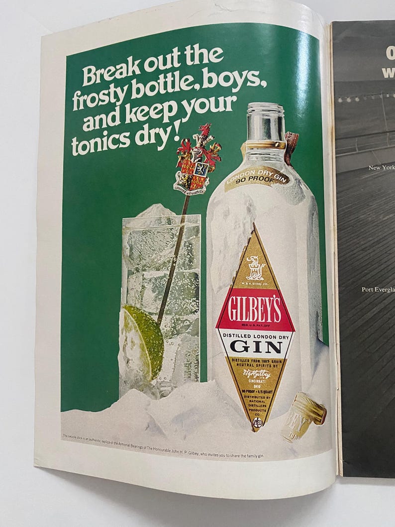 May include: A vintage advertisement for Gilbey's London Dry Gin. The ad features a frosted bottle of gin with a lime wedge and ice in a glass. The text reads "Break out the frosty bottle, boys, and keep your tonics dry!"