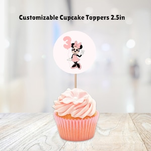 May include: Pink and white cupcake topper with a Minnie Mouse character holding a balloon with the number 3 on it. The topper is 2.5 inches in diameter.