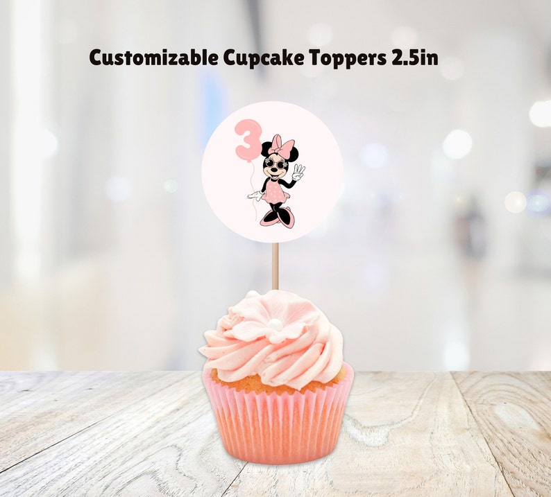 May include: Pink and white cupcake topper with a Minnie Mouse character holding a balloon with the number 3 on it. The topper is 2.5 inches in diameter.