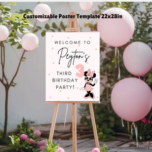 May include: A pink and white welcome sign with polka dots and a Minnie Mouse character. The sign says "Welcome to Peyton's Third Birthday Party!"