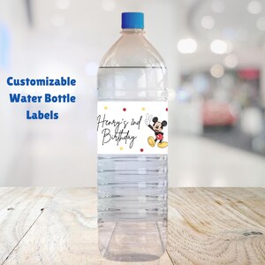 May include: A clear plastic water bottle with a label that says "Henry's 2nd Birthday" and features a cartoon image of Mickey Mouse. The label has red, yellow, and white polka dots.