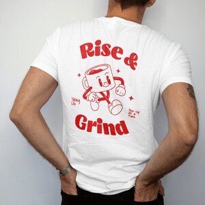 Puede incluir: Camiseta blanca con un gráfico rojo de una taza de café corriendo y el texto "Rise & Grind" con el lema "Taking Life One Sip at a Time".