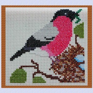 May include: Cross-stitch pattern of a robin redbreast perched on a branch with green leaves. The bird is surrounded by brown and green stitches, creating a realistic depiction of its natural habitat.