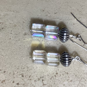 May include: A pair of silver earrings with iridescent clear glass cube beads and silver ball accents.