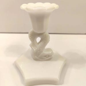 May include: White milk glass candle holder shaped like a fish with a flower-shaped top.