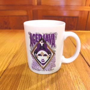 May include: White ceramic mug with a purple and gold design featuring a stylized face and the text "Aged Java Starbucks Coffee".