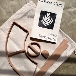 May include: A set of three ceramic mugs with a speckled, matte finish. Each mug features a different color: light blue, cream, and gray. The mugs have a simple, modern design and a comfortable handle.
