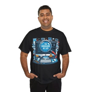 May include: A black t-shirt featuring a graphic of a computer screen with the text "I'm Debugging My Life" inside a magnifying glass. The graphic is surrounded by various computer-related icons.