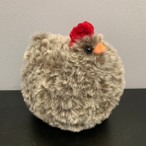Fluffy chicken in brown and white fluffy yarn with red comb and orange beak in chenille yarn