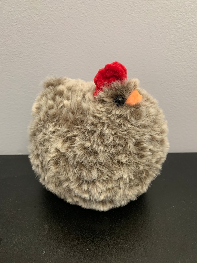 Fluffy chicken in brown and white fluffy yarn with red comb and orange beak in chenille yarn
