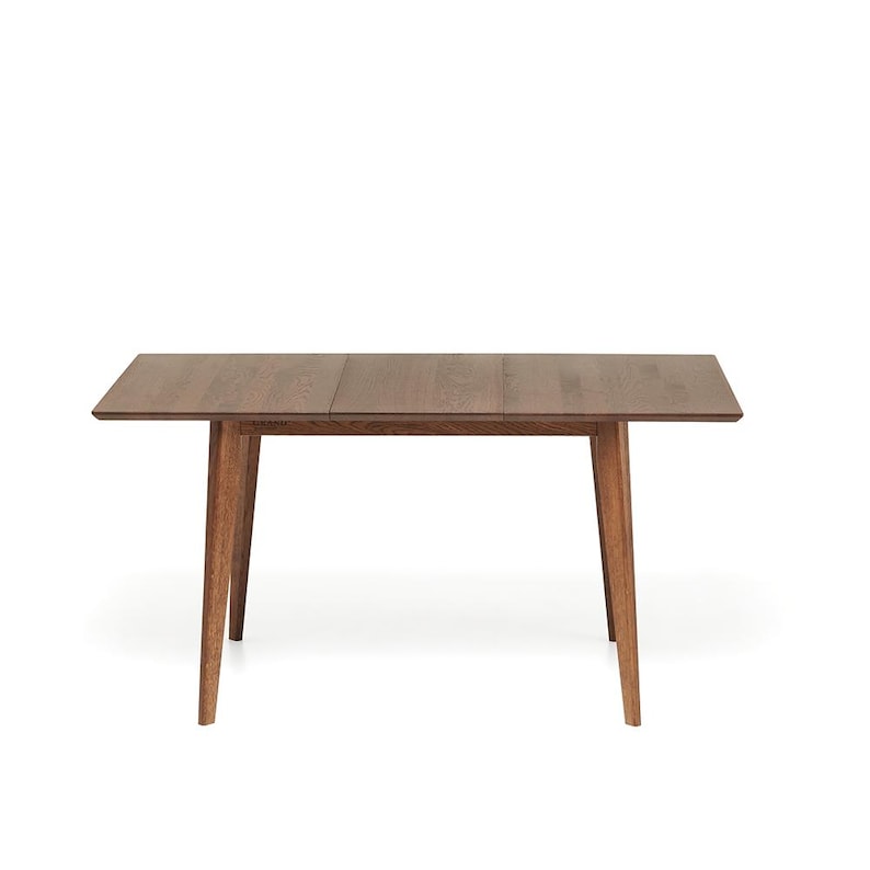May include: A rectangular wooden dining table with a dark brown finish. The table has four angled legs and a simple, modern design. The table is approximately 60 inches long and 36 inches wide.