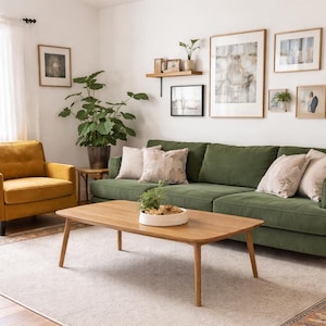 Könnte beinhalten: Ein Wohnzimmer mit einem grünen Sofa, einem gelben Sessel und einem Holztisch. Der Raum ist mit gerahmten Bildern und einem neutralen Teppich ausgestattet. Eine große Topfpflanze und Kissen tragen zur gemütlichen Atmosphäre bei. Der Couchtisch ist etwa 120 cm lang.