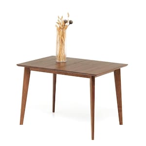 May include: A rectangular wooden dining table with four angled legs. The table is a medium brown color and has a smooth surface. A clear glass vase with dried flowers sits on top of the table.