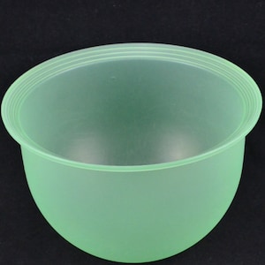 Könnte beinhalten: Eine gefrostete grüne Plastikschüssel mit einem glatten, abgerundeten Boden und einem leicht ausgestellten Rand.