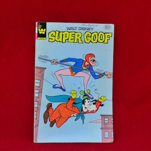 May include: A vintage comic book cover featuring Walt Disney's Super Goof. The cover shows Goofy dressed as a superhero, flying through the air with a red cape and a red and blue costume. The text on the cover reads "Walt Disney Super Goof" and "60c".