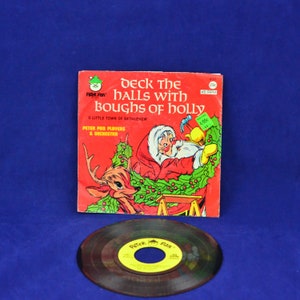 May include: A red and green Peter Pan record with a picture of Santa Claus and a reindeer on the cover. The record is titled "Deck the Halls with Boughs of Holly" and features the Peter Pan Players and Orchestra. The record is 45 RPM and is 29¢.