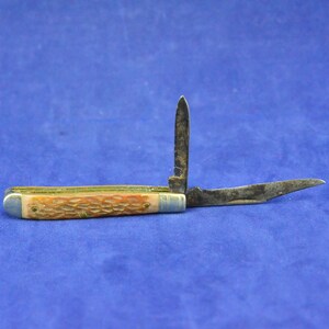 May include: A vintage two-blade pocket knife with a brown faux-horn handle and a silver metal frame.