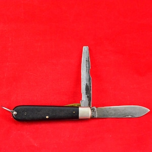 Könnte beinhalten: Ein Taschenmesser mit schwarzem Griff, mit einer einzelnen Klinge und einer kleinen Schraubendreherklinge. Das Messer ist geöffnet und die Klinge ist sichtbar.