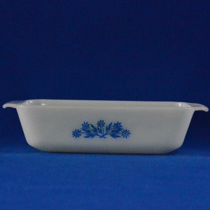 Puede incluir: Plato para hornear rectangular blanco con diseño floral azul. El plato tiene dos asas a los lados.