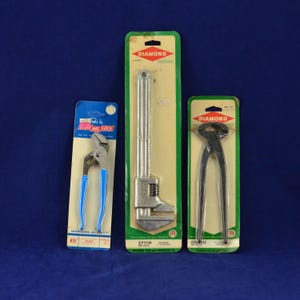 May include: Three Diamond brand tools on display: a 6.5-inch adjustable wrench, a long wrench, and a pair of pliers. The tools are packaged on green and yellow cardboard with the Diamond logo.