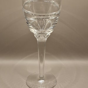 Peut inclure: Un verre à vin en verre transparent avec une longue tige et un large bol. Le bol présente un motif décoratif de lignes gravées.