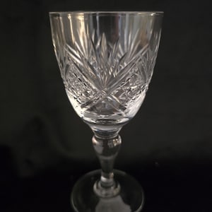 May include: A clear glass stemmed shot glass with a cut crystal design.